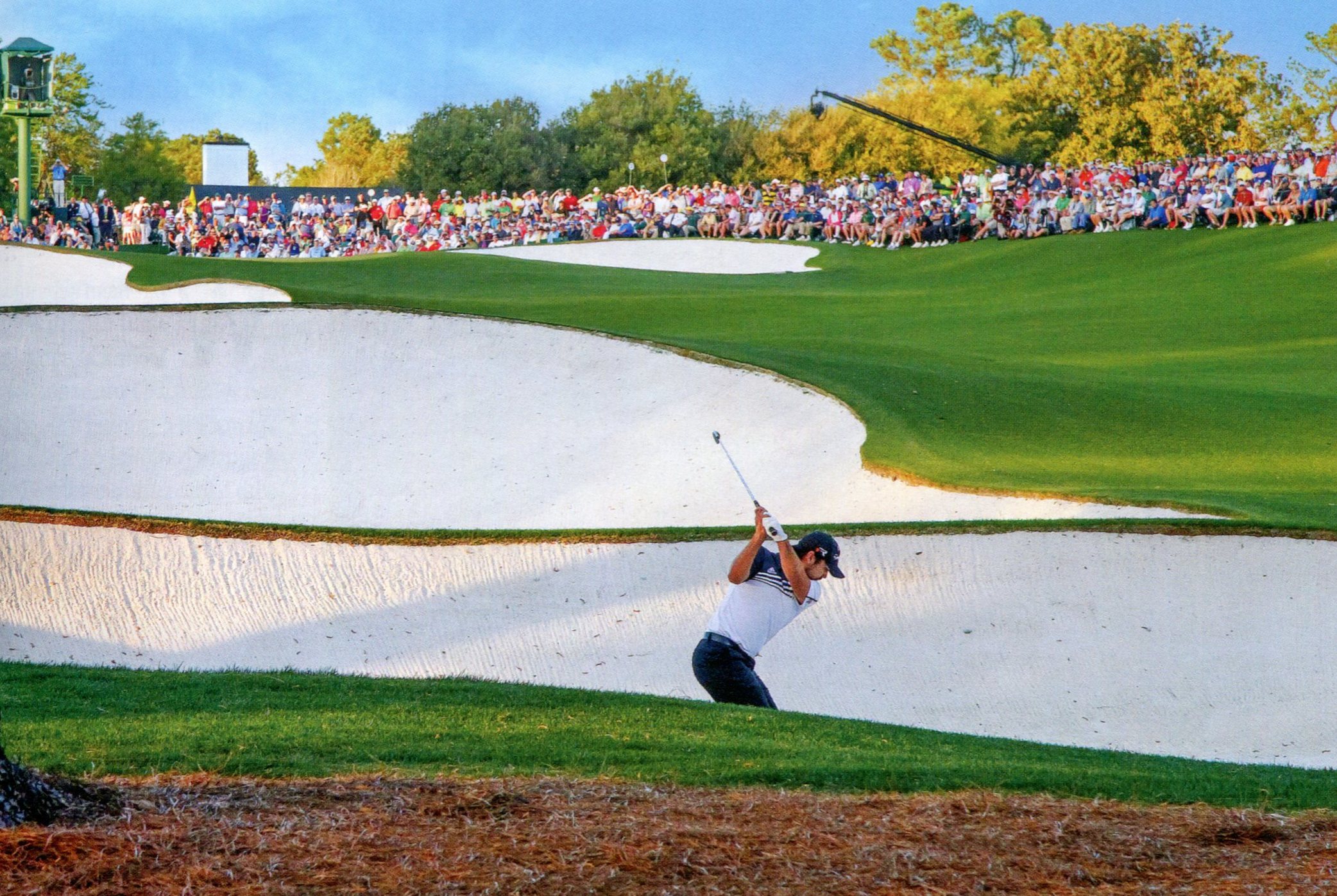 A photo a golfer hitting from a white sand bunker at Augusta National.