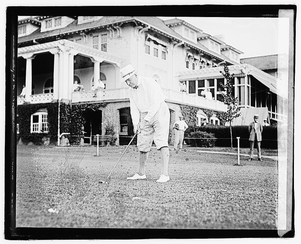 Vintage photo of President Harding working on his putting.