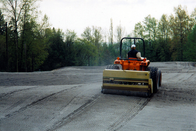 A photo of a golf course fairway being seeded.